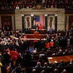 On the left, Democrats stand and applaud while, on the right, Republicans sit